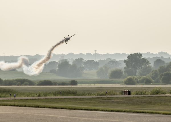 a small plane is flying low over a field.