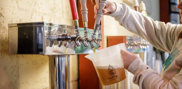 A woman pouring a beer into a glass.