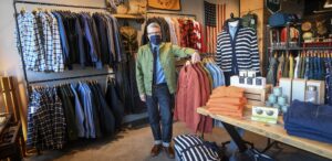 a man wearing a face mask in a clothing store