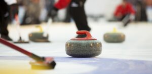 a group of people standing around a curling rink