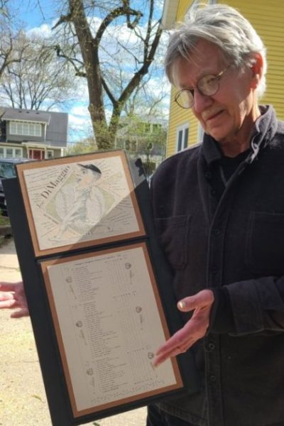 A man is holding up a map of a house.