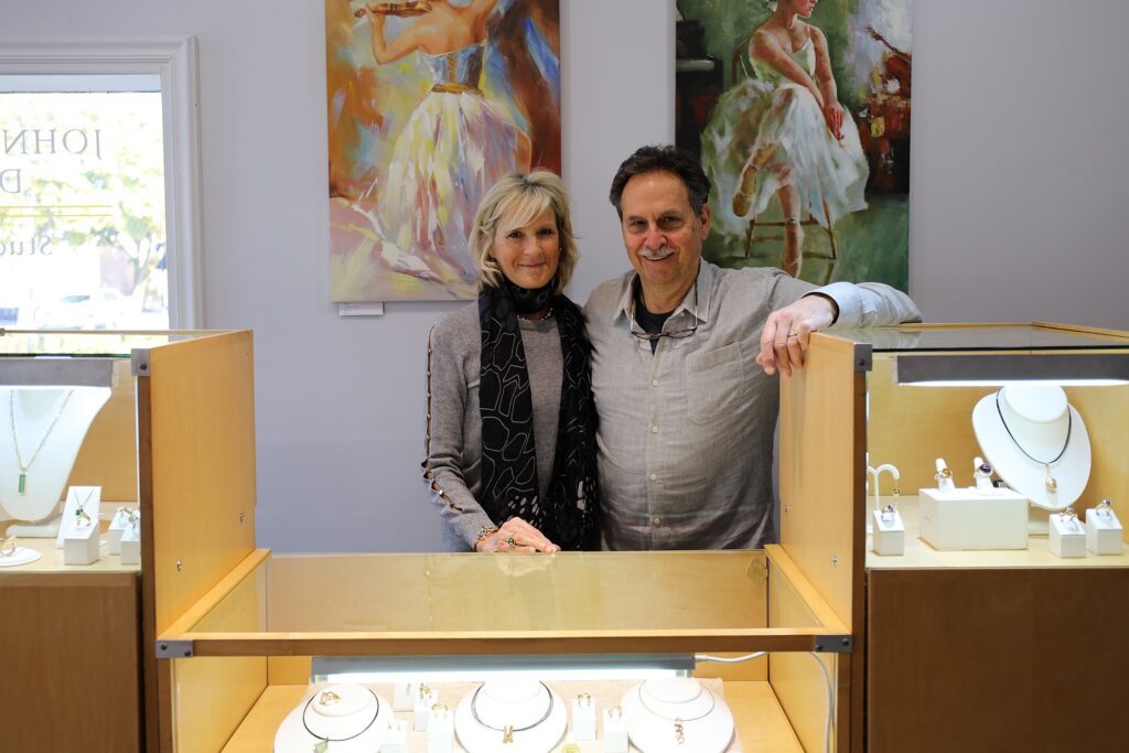 Christine and John Strobel of John/Christine Designs in downtown Middleton stand behind a jewelry counter in their store.