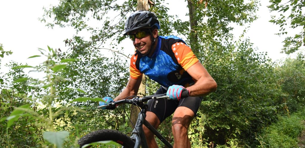 a man riding a bike down a dirt road