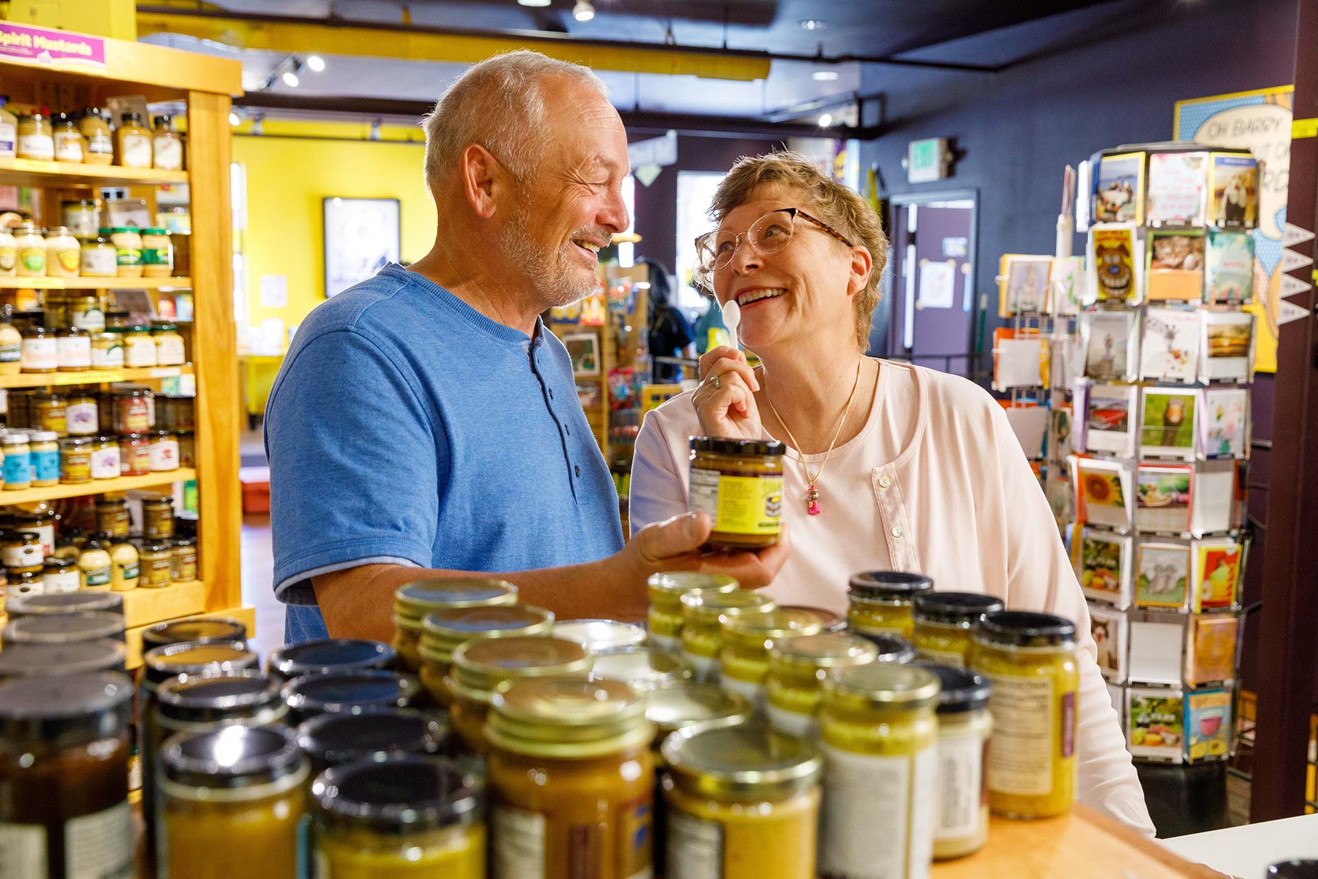 a man and woman standing in front of jars of food