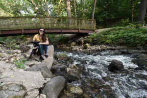 a woman sitting on a rock next to a river