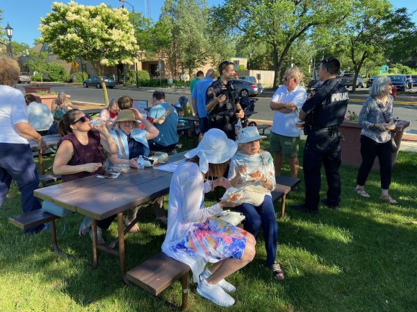 a group of people sitting around a picnic table.