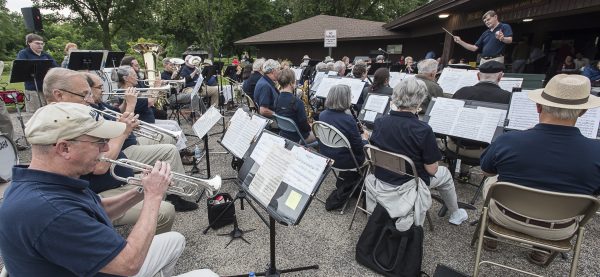 a group of people playing musical instruments in front of a building.