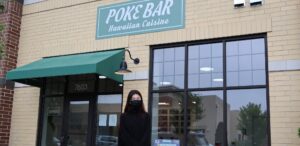 a woman standing outside of a restaurant with a green awning