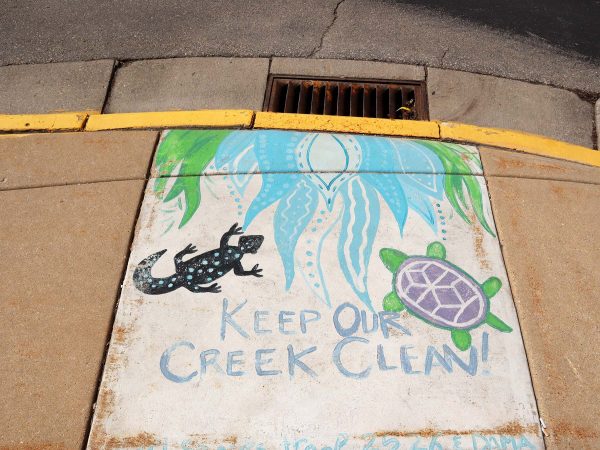 a sign on the side of a building that says keep our creek clean.
