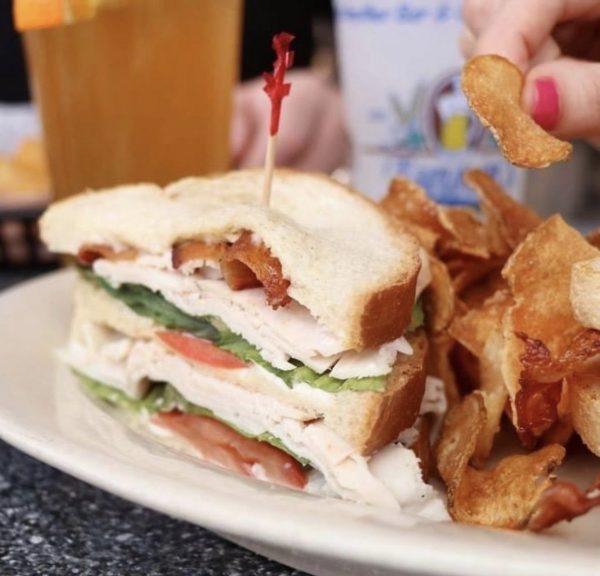 a close up of a plate of food with a sandwich and chips.